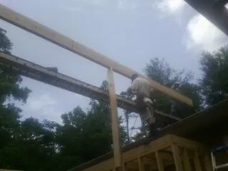 Carpenter setting a ridge beam over a new addition frame — Ice Dam Removal by Roofing Brothers in Trent