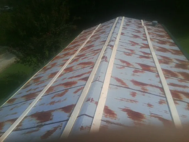 Rusted metal roof panels with new wood purlins before replacement — Storm Damage Roof Repair in Trent by Roofing Brothers