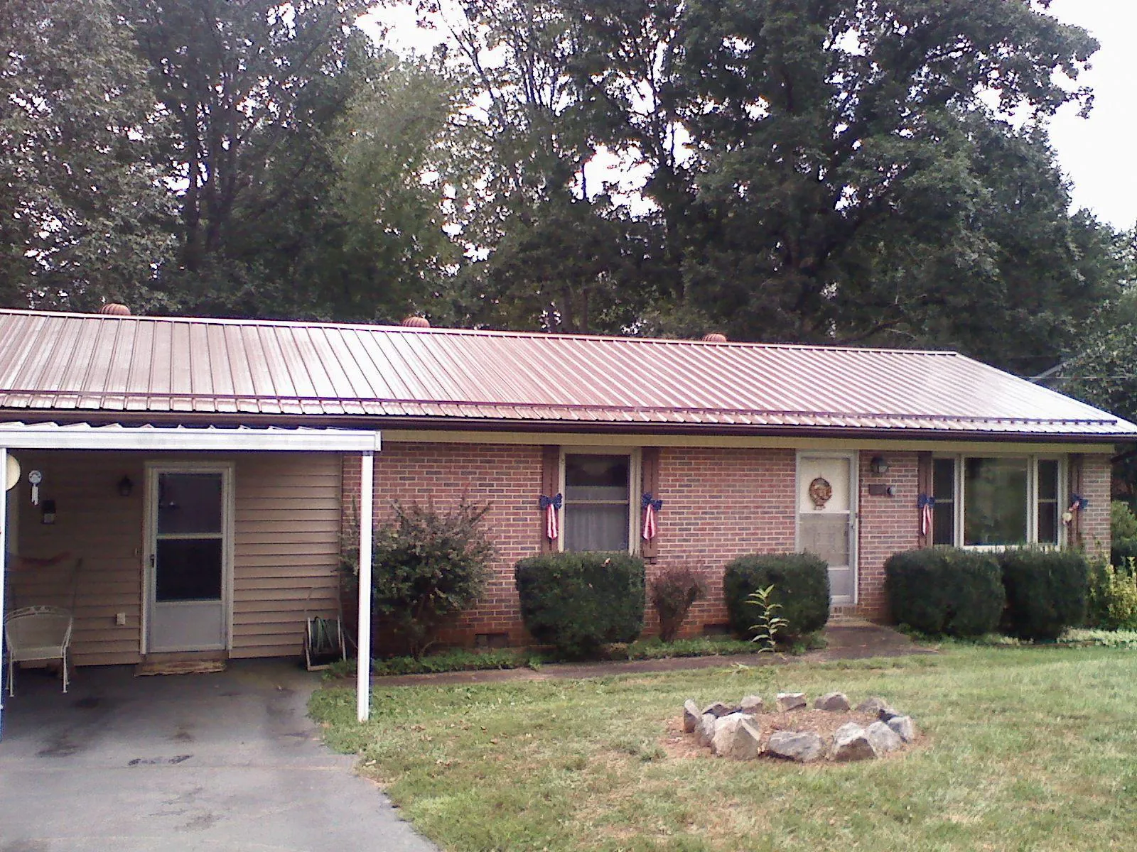 Bronze metal roof and carport on a brick ranch home — Roof Repair work by our crew in Trent